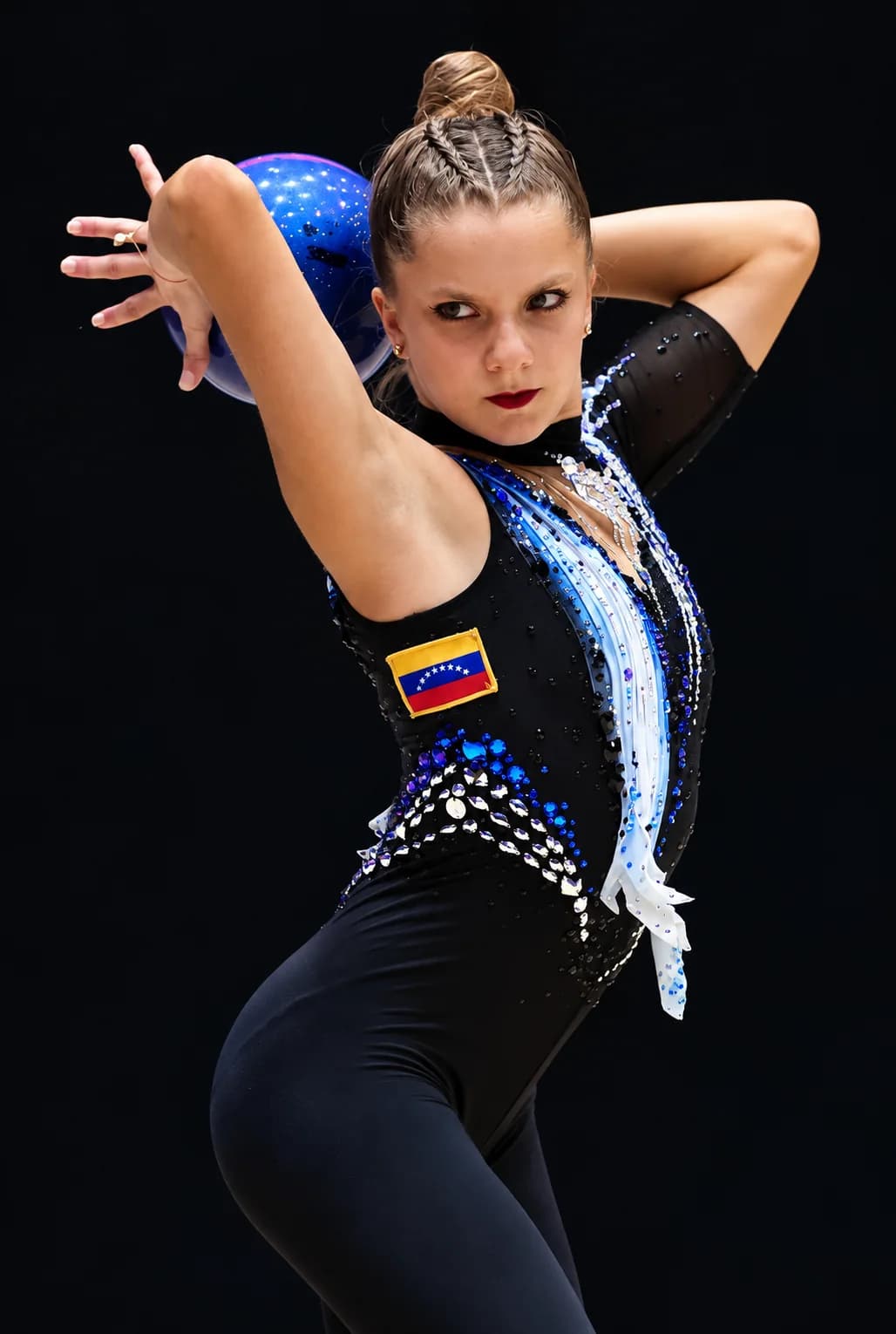 Rhythmic gymnast holding a blue ball behind her head