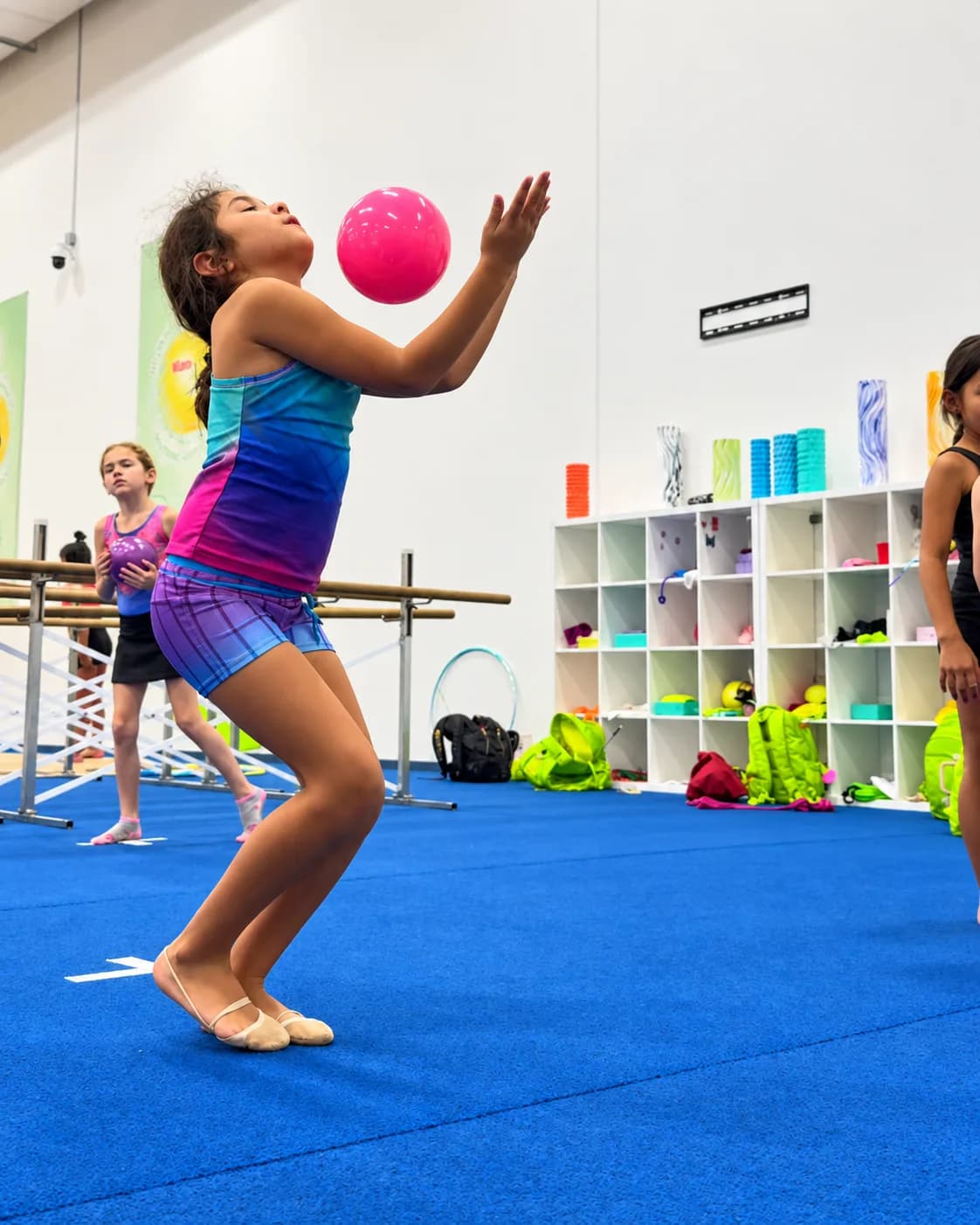 A girl catching a pink ball in class