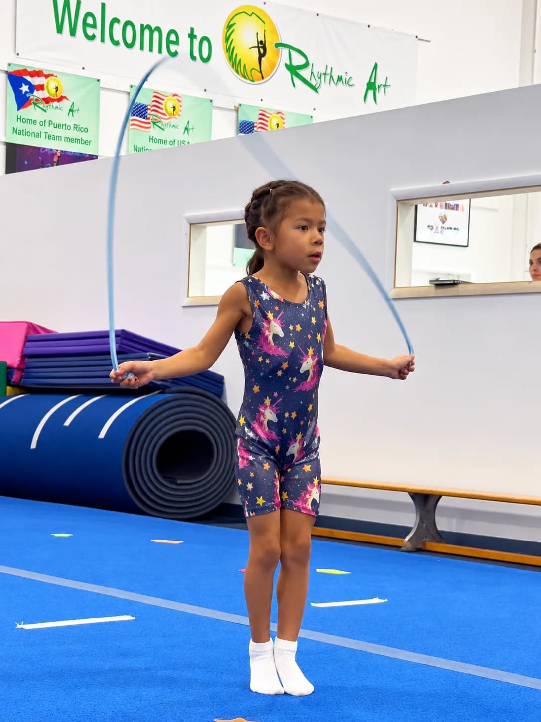 A girl in a fitted one-piece and white socks jumping rope in class at Rhythmic Art