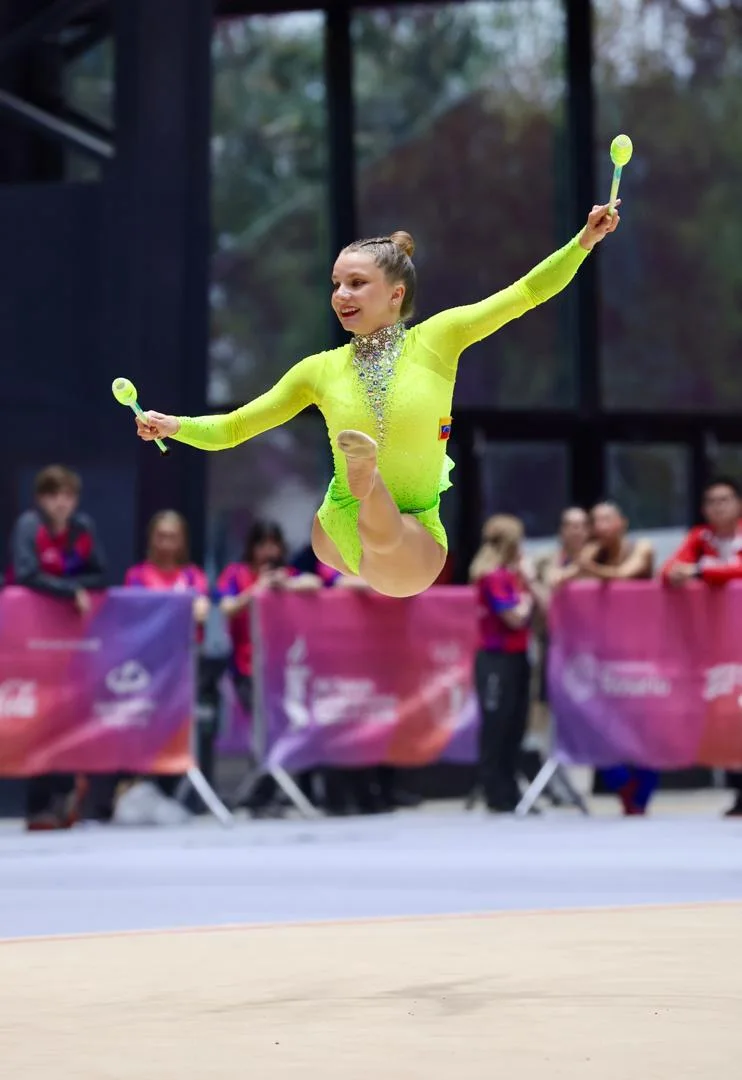 Jimena Dominguez of Rhythmic Art leaping with clubs at the South American Games in Santa Fe