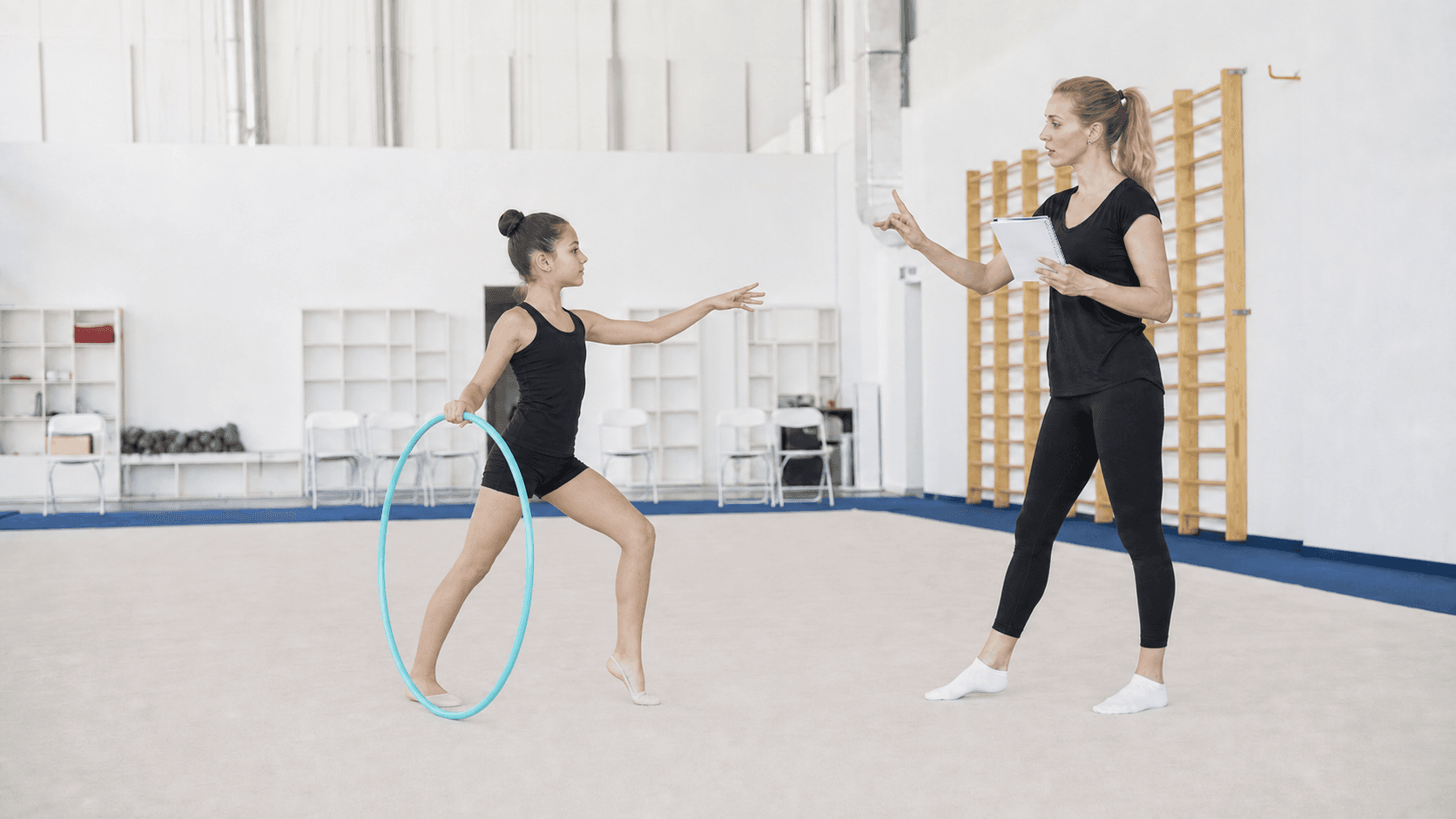 Coach reviewing an athlete holding a hoop in a shallow lunge during a private lesson